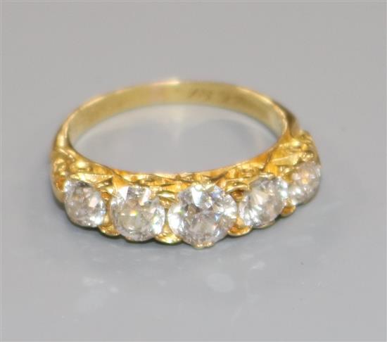 A late Victorian yellow metal and graduated five stone diamond half hoop ring, size J.